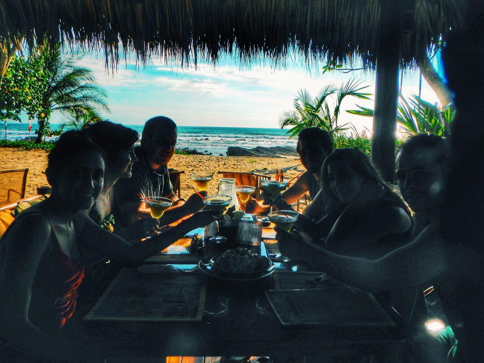 People under a hut having drinks by the beach in Costa Rica.