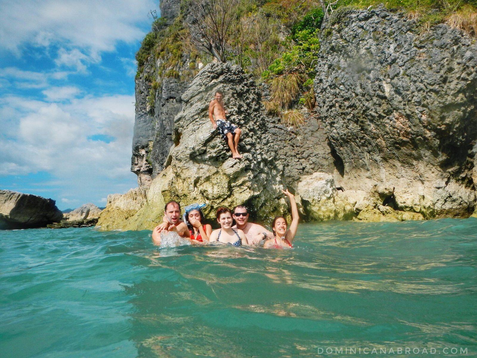 A group of five people swimming and one person sitting on a rock in Costa Rica.