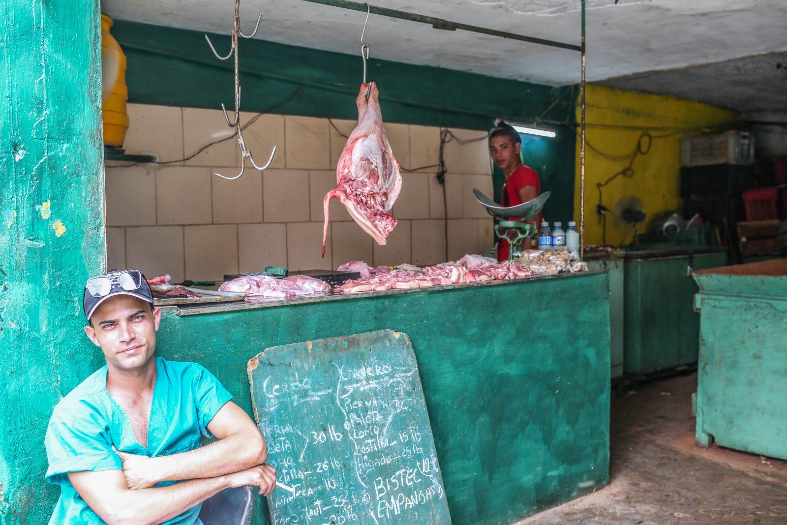 Two vendors at a meat shop in Cuba