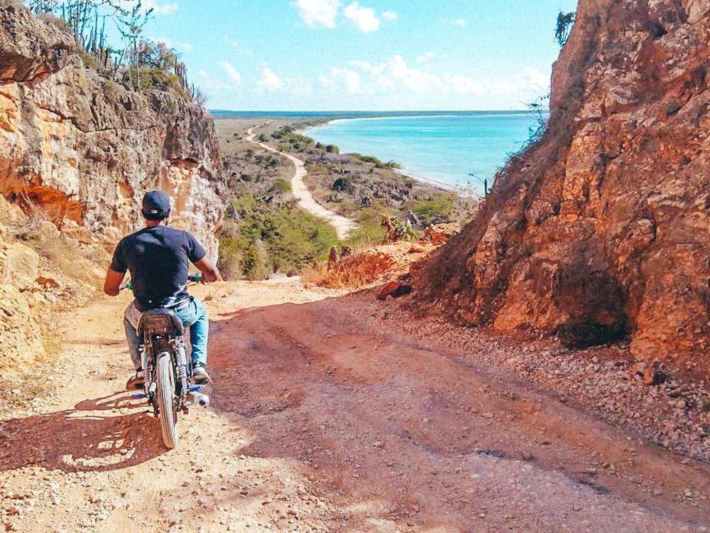 A man riding a motorcycle towards Bahia de las Aguilas beach