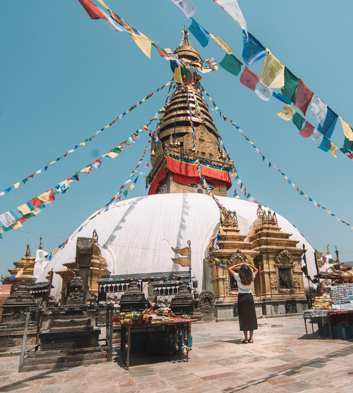 A woman standing in front of the Monkey Temple in Kathmandu.