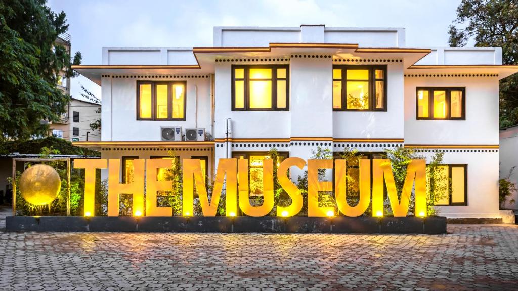 The outside of a white building with giant letters "The Museum" at its front.
