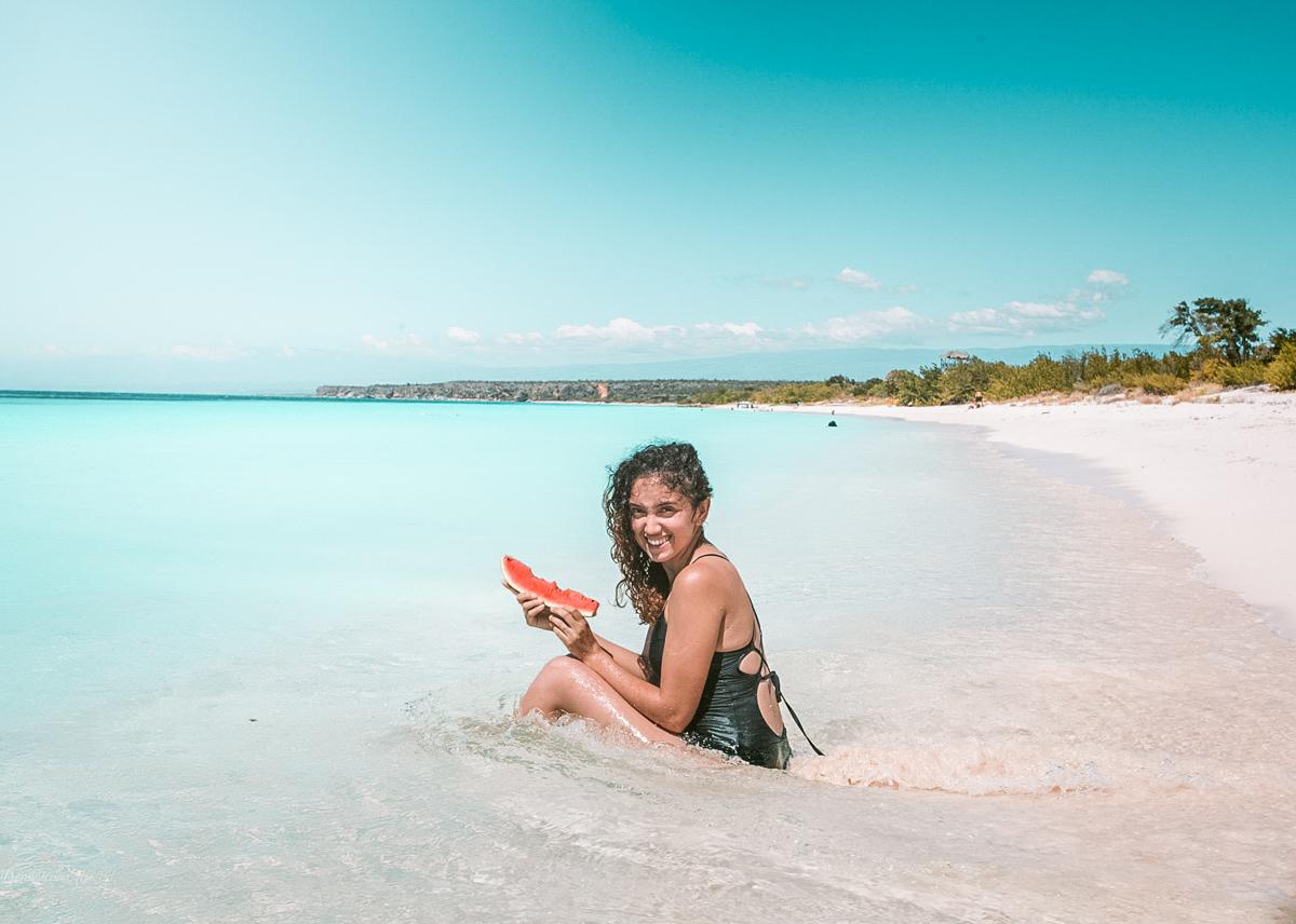 A woman eating a slice of watermelon at Bahia de las Aguilas beach.