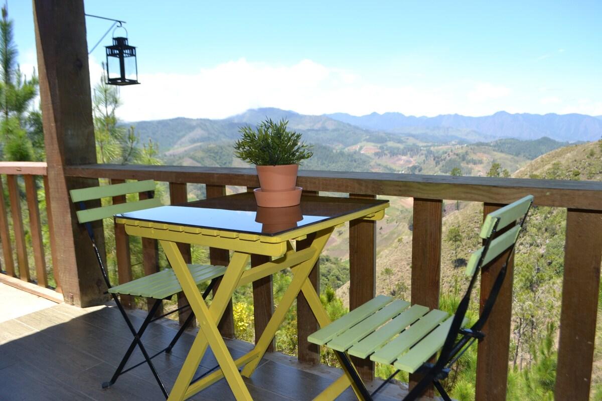 An outdoor sitting area of an accommodation with view of the Dominican mountains.
