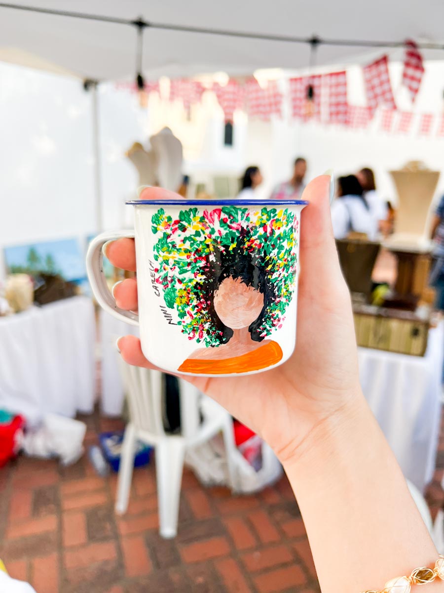 A white cup with an illustration of a Dominican girl on it.