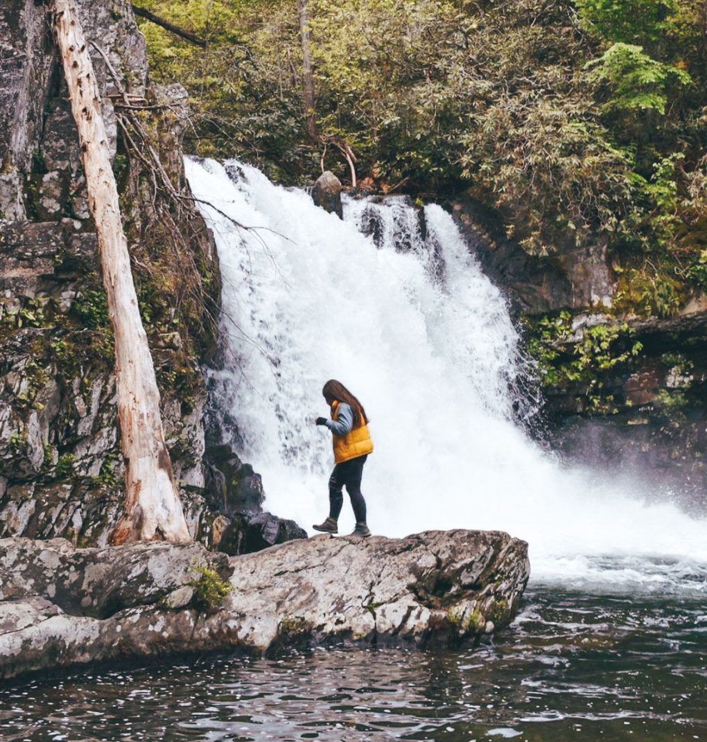 a girl walking by waterfall