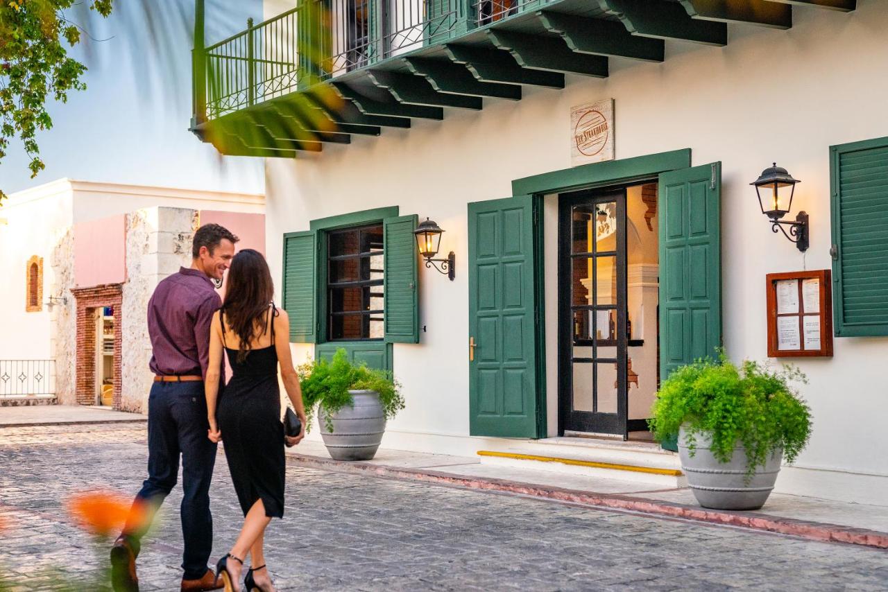 A man and a woman walking to an entrance of a boutique hotel.