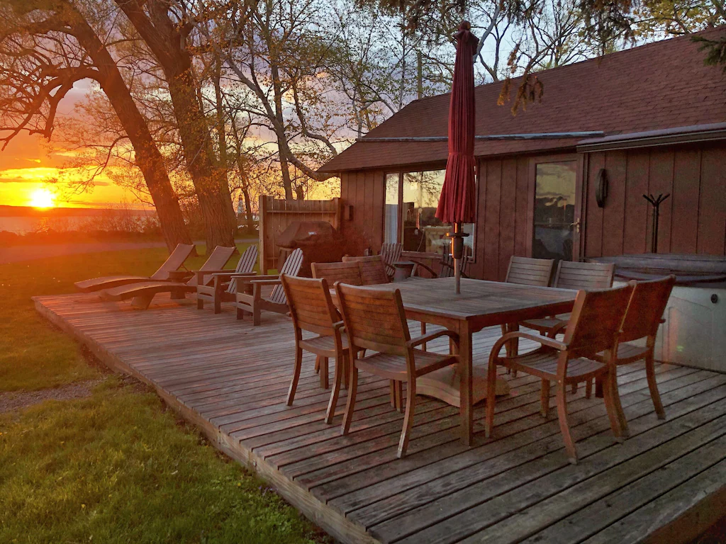 The outdoor sitting area of a cabin at sunset.