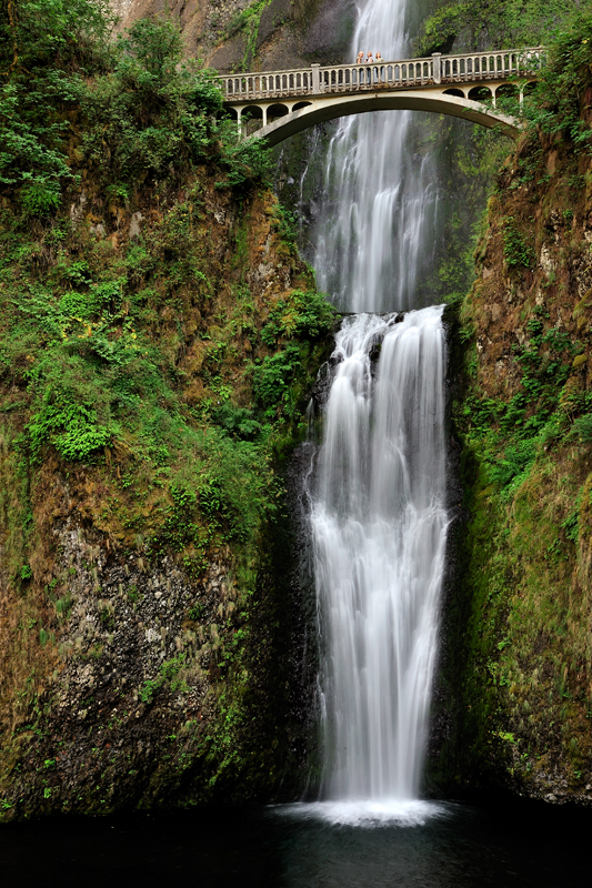 A waterfall with a bridge over it.
