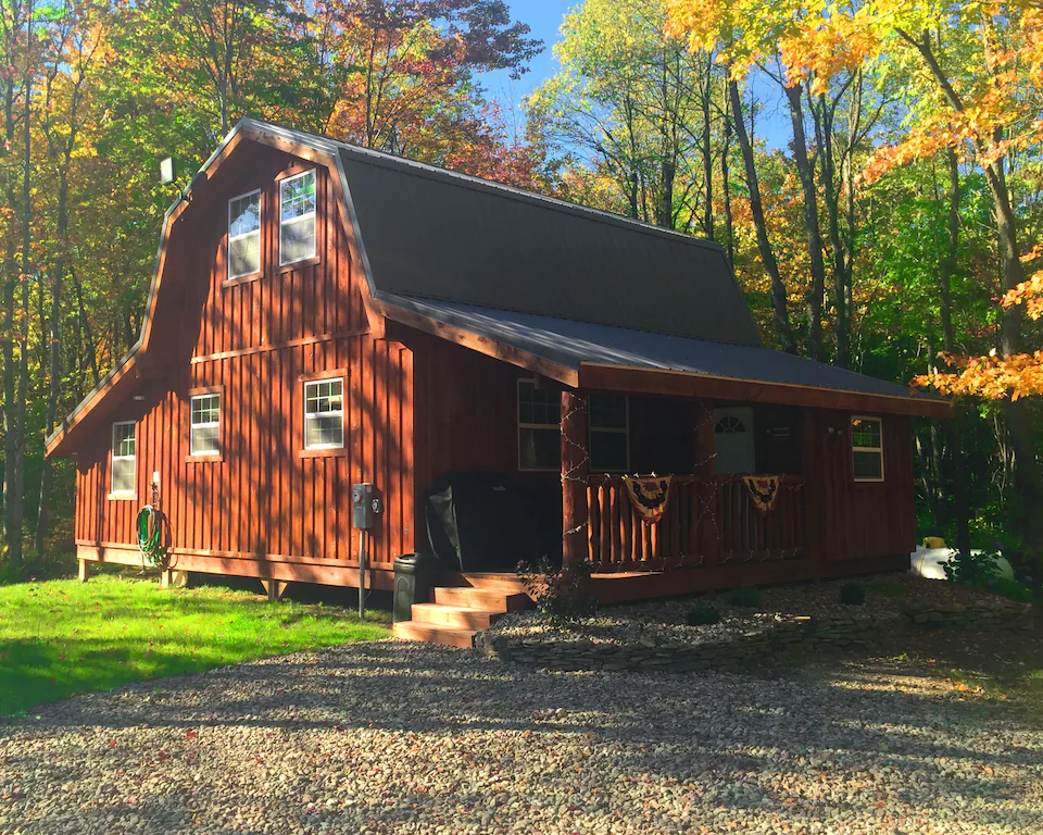 A red cabin in the woods in the fall.