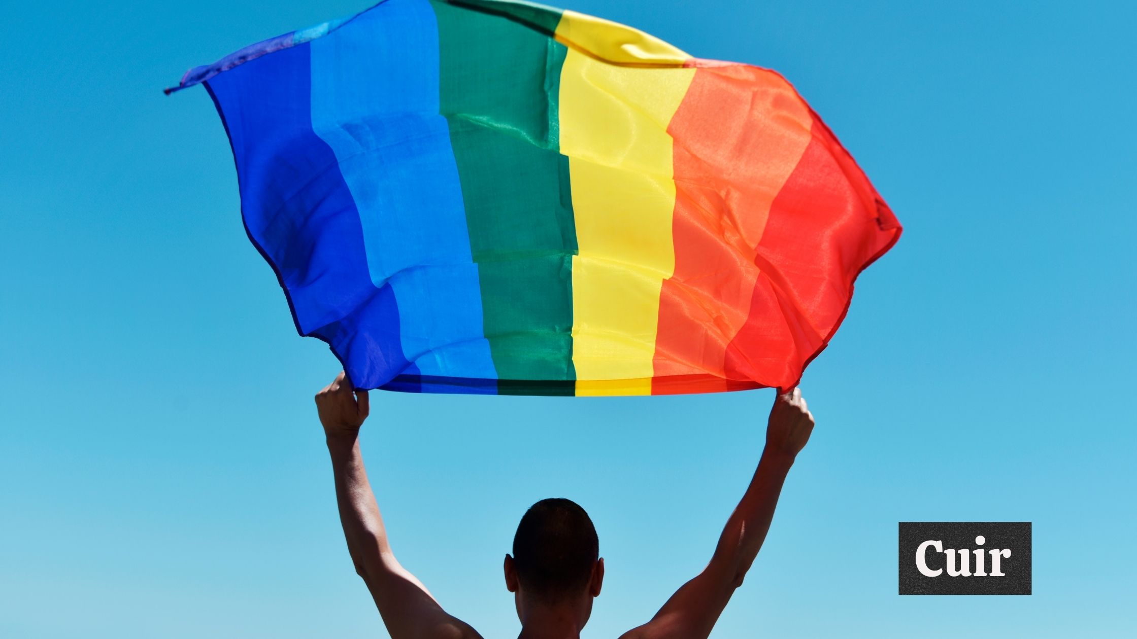 A person facing backwards holding a rainbow flag; "Cuir," a Dominican slang, text in image.
