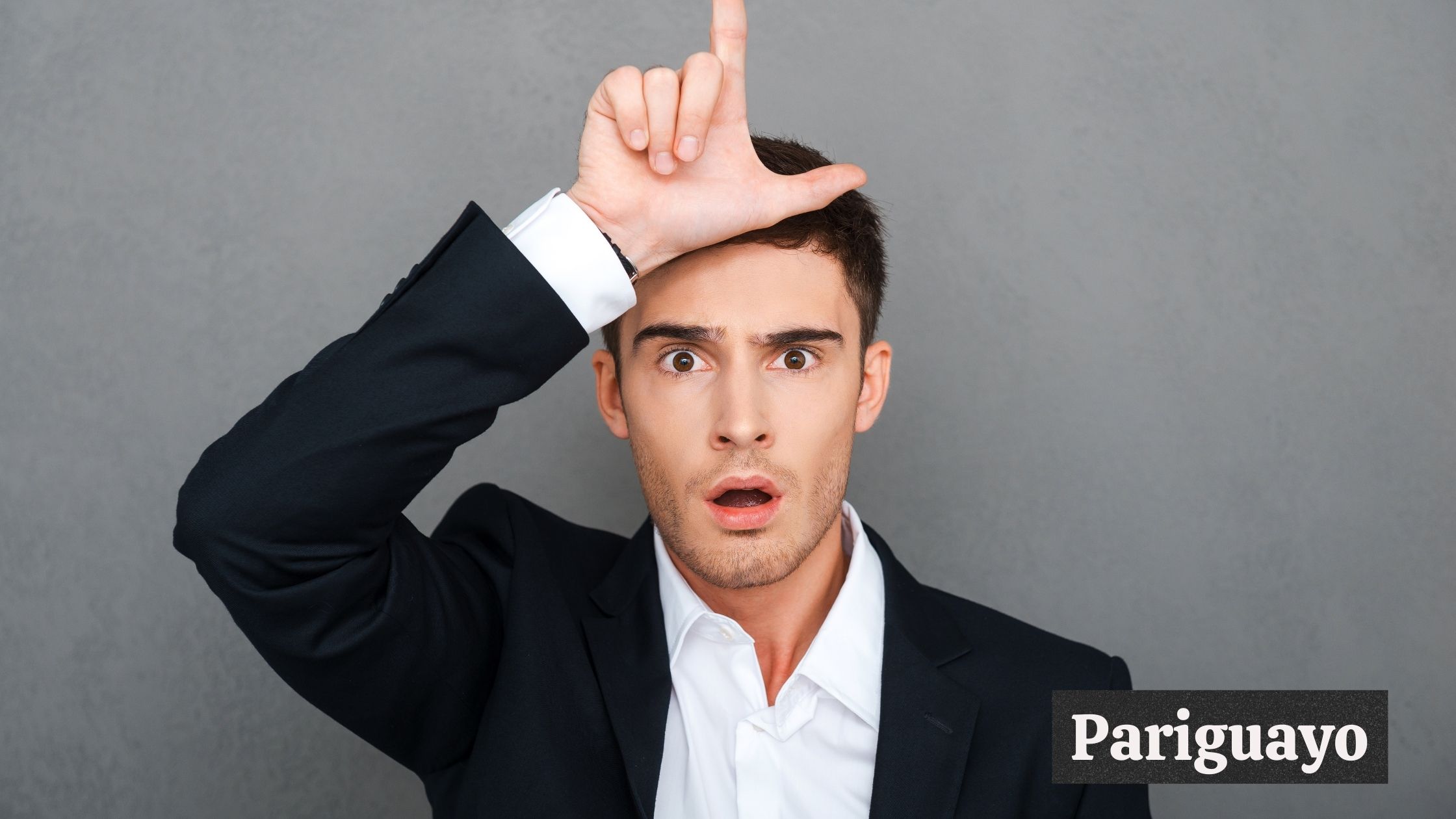 A man in suit making a loser sign; "Pariguayo" text in image.