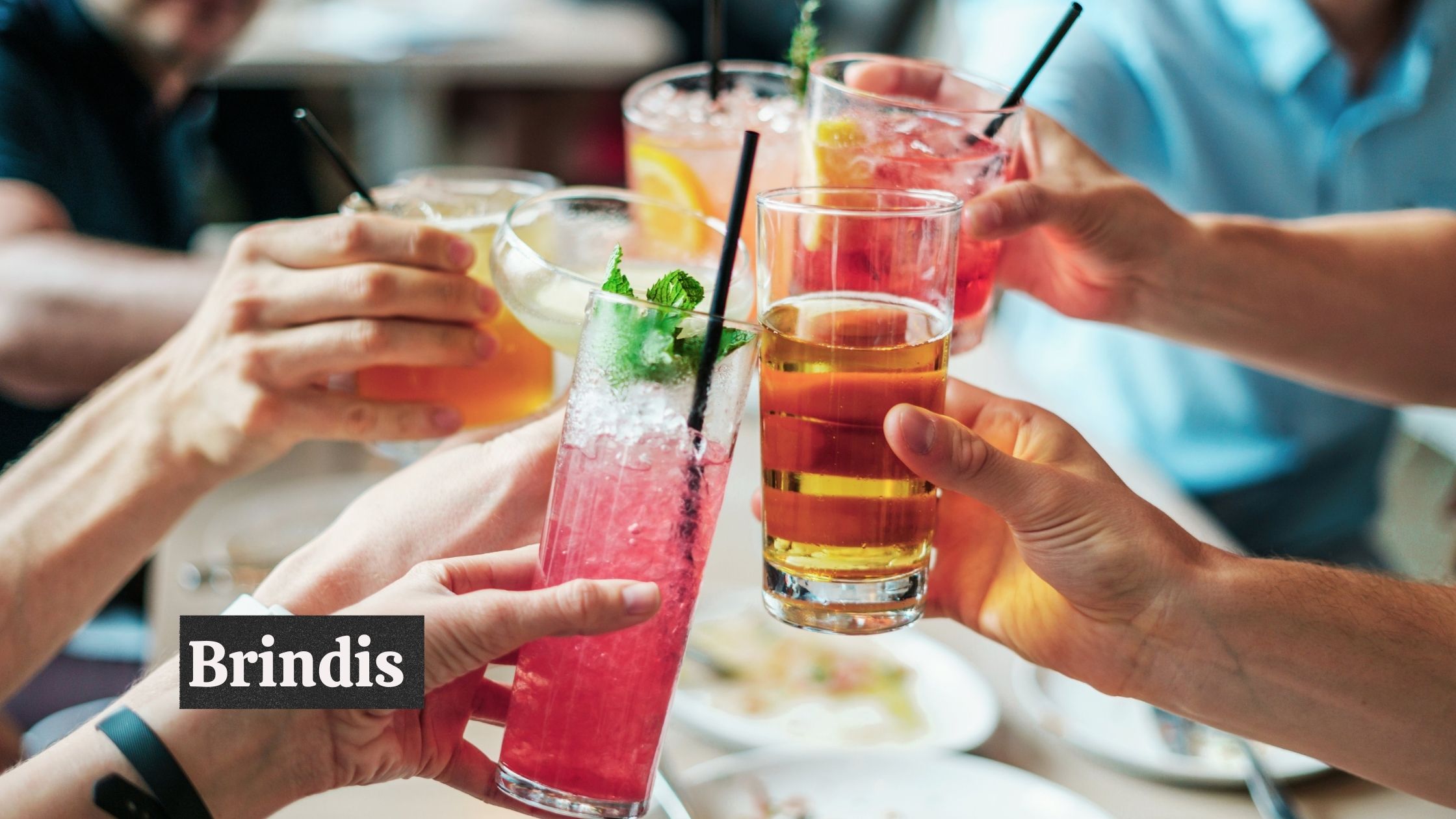 Cocktail glasses being clinked; "Brindis" text in image.