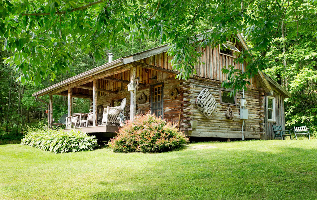 A log cabin surrounded by plants and trees in Ellicottville, New York.