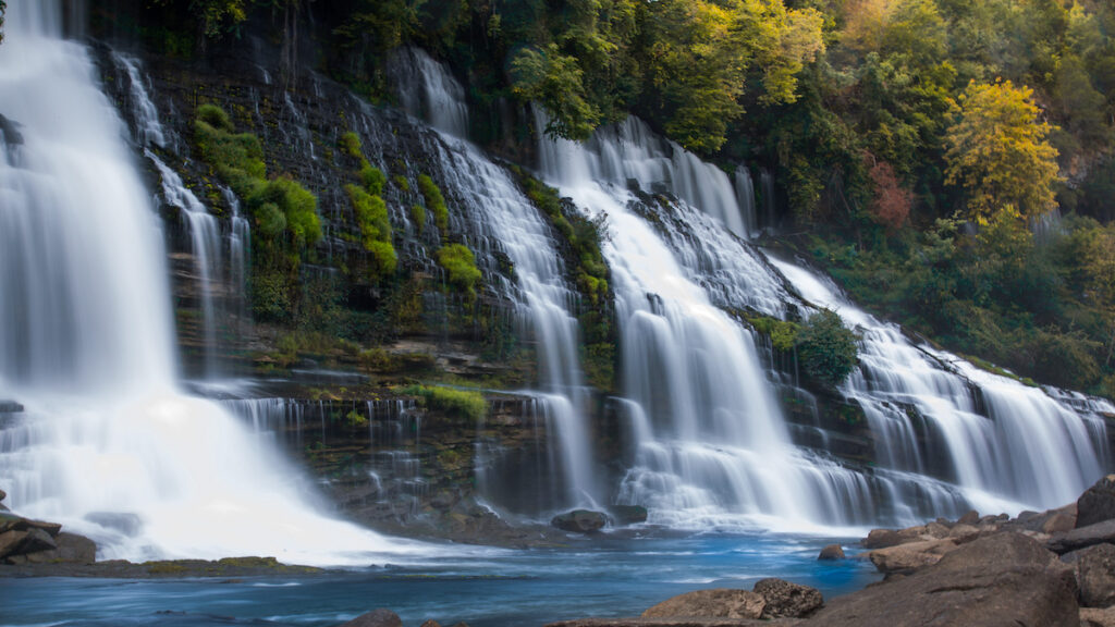 a cascade of waterfalls with blue water