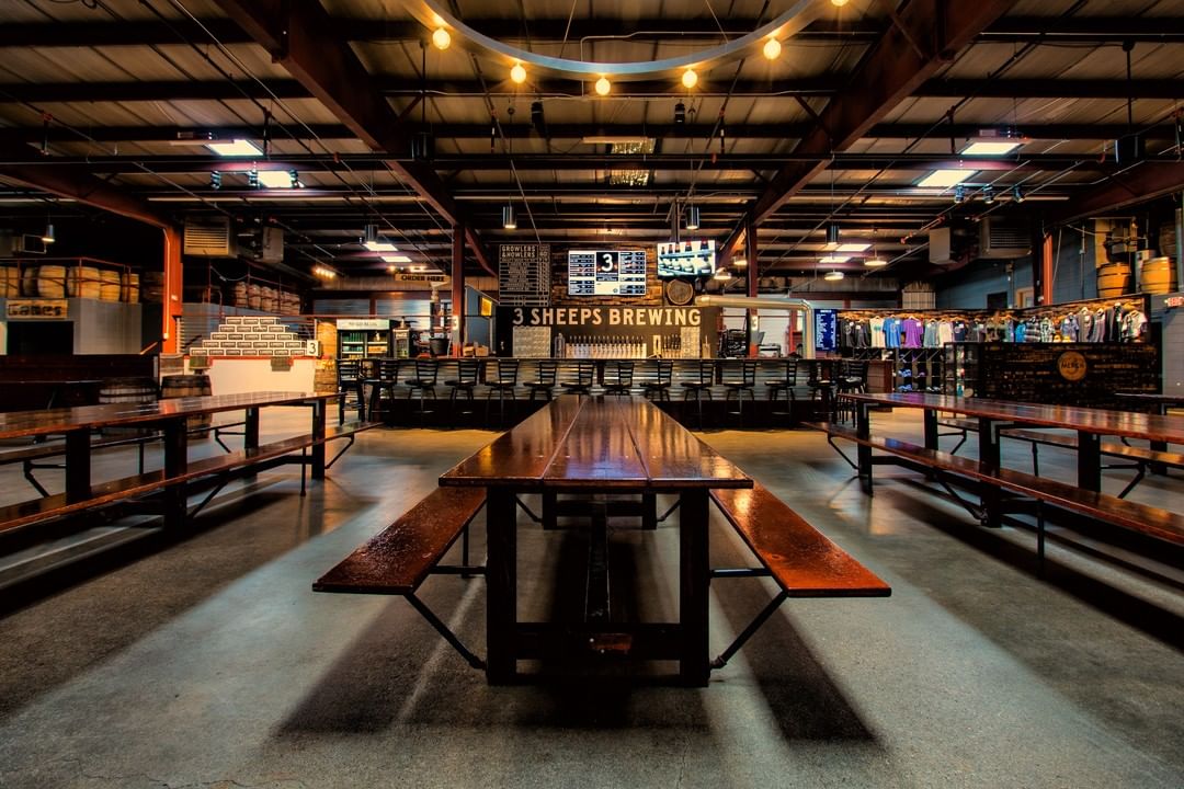 Interior of a brewery with huge long tables in industrial style.