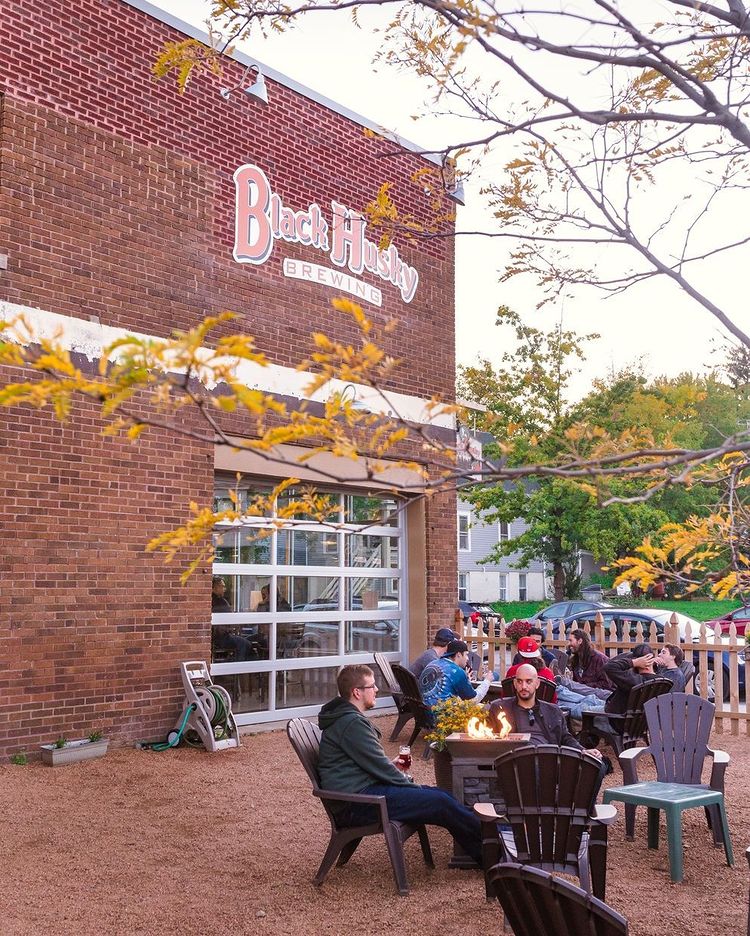 From of the brewery with people sitting around the fire place and enjoying beer.