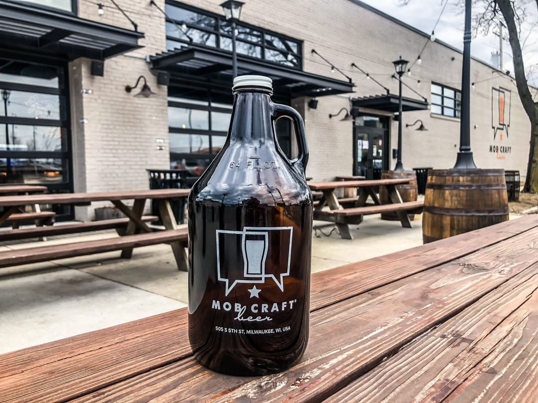 The bottle of beer on the table infant of the brewery highlighting the exterior part.