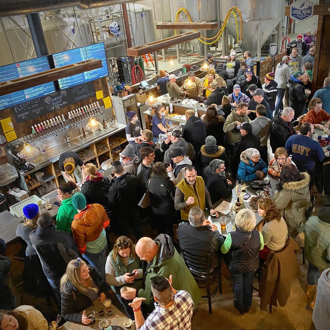 Interior of the brewery crowded with people enjoying their beers.