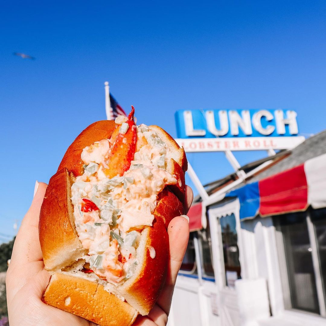 Typical sandwich with lobster that is a specialty of the restaurant and the restaurant as a blurry background. 