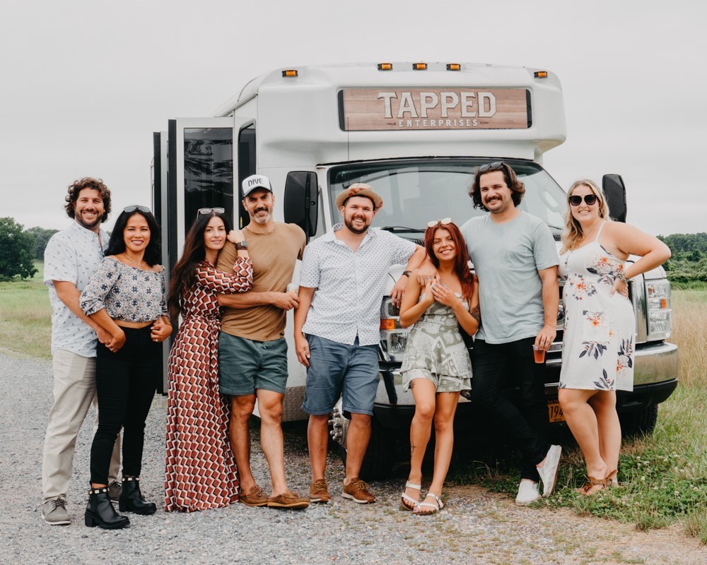 People infront of the van that they use for round-trip tours. 