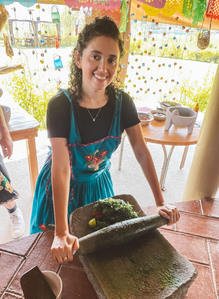 A woman cooking at an Oaxacan cooking class, one. ofthe best things to do in Oaxaca.