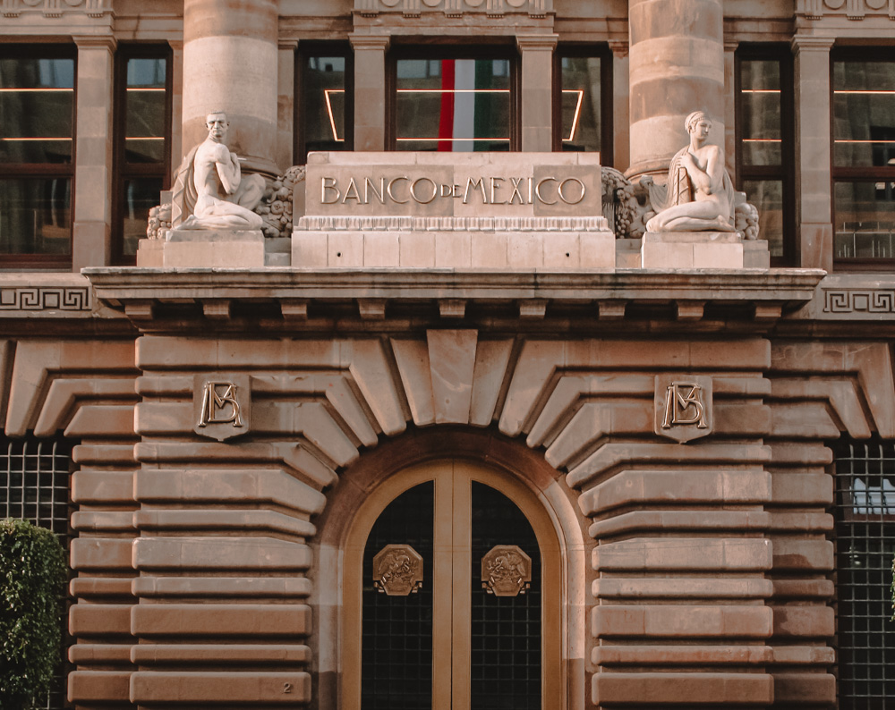 The entrance of Museum of the Bank of Mexico with statues above the doors.