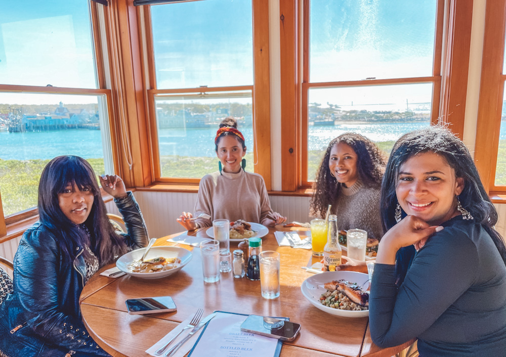 Four women at a round table having a meal inside a restaurant in Montauk.