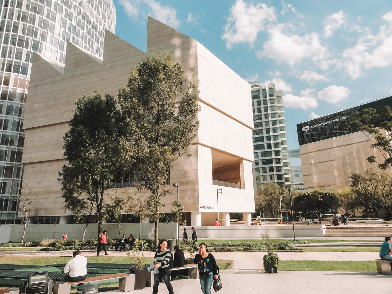 People at a park with Jumex Museum in the background.