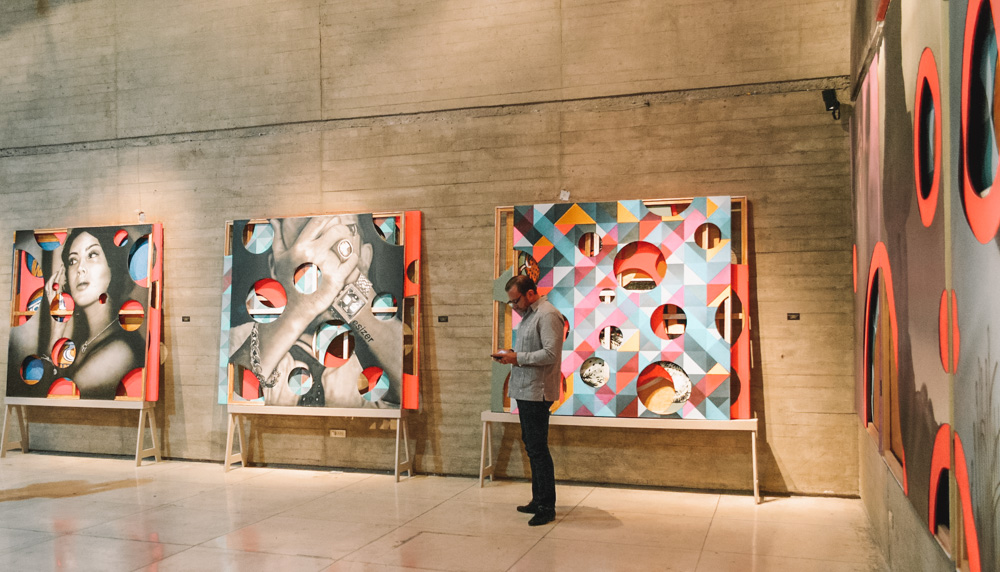 A man standing in front of artworks at Modern Art Museum.