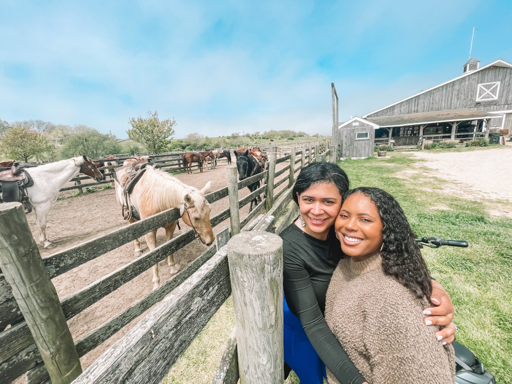 Two women posing with horses at a ranch in Montauk, Long Island.