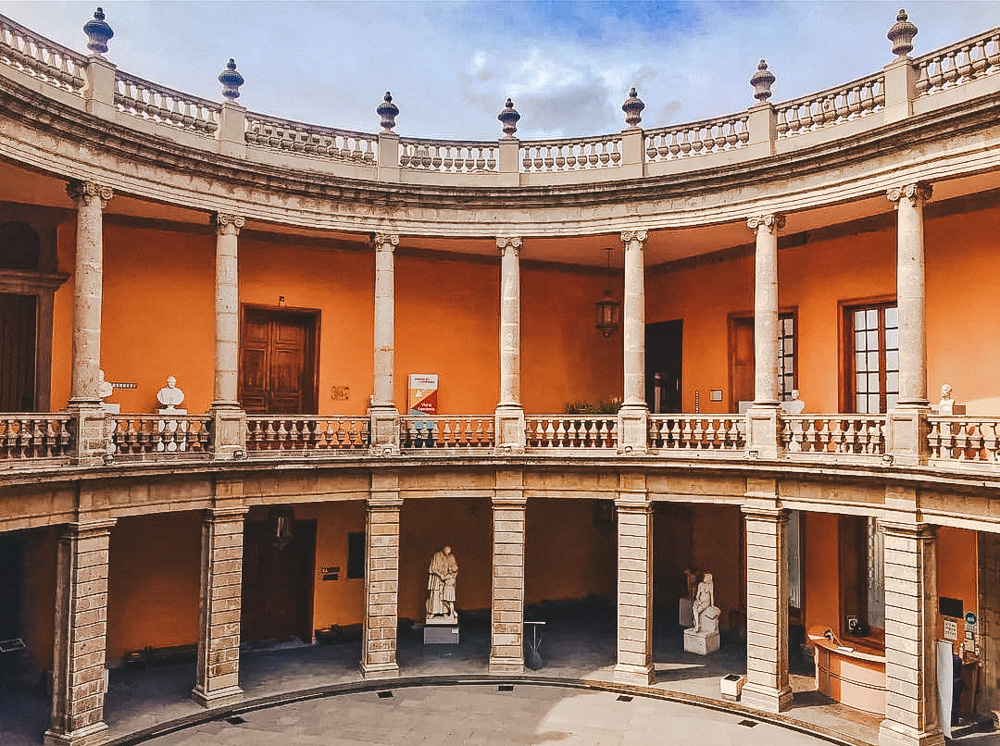 The orange courtyard of the National Museum of San Carlos.