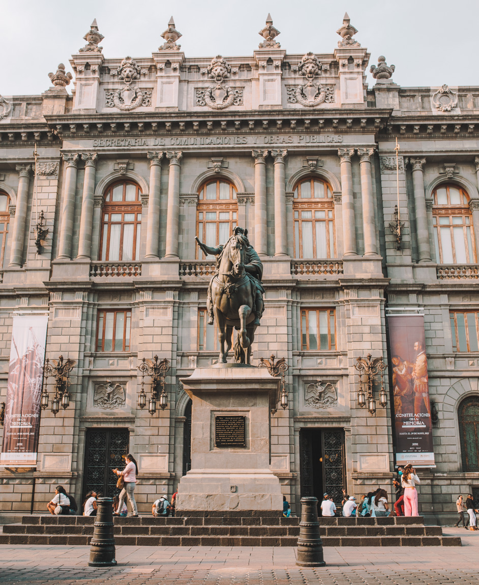 A statue of a man riding a horse outside the National Art Museum building in Mexico City.