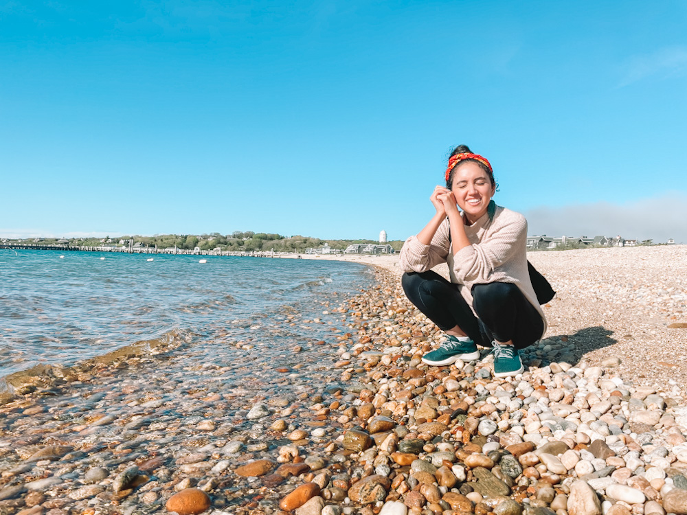 A woman sitting on a pebbled beach in Montauk.