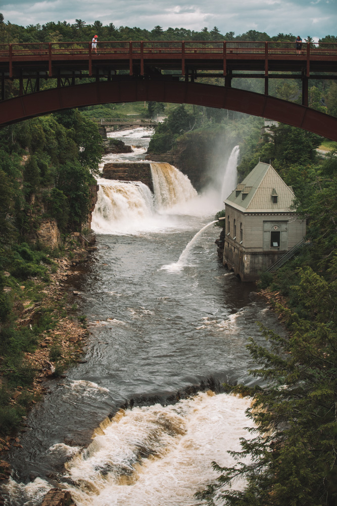 Waterfalls with a red bridge over it.