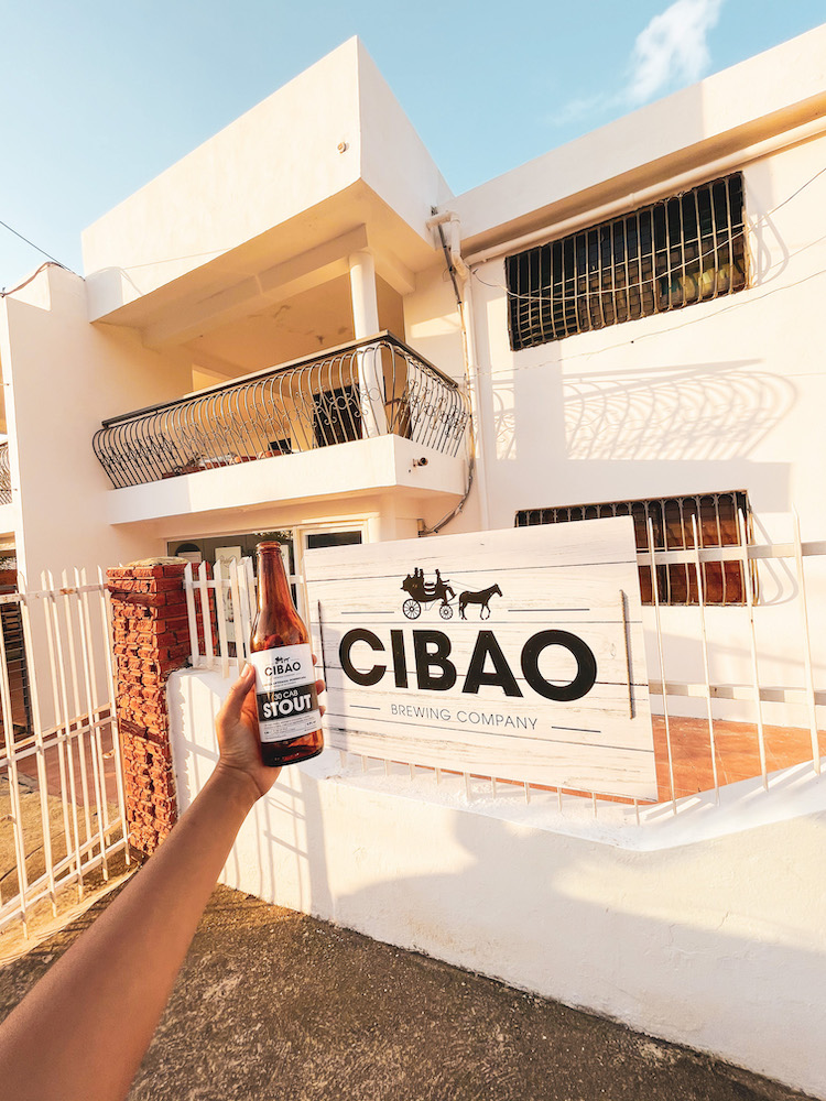 A bottle of drink. in front of a building.