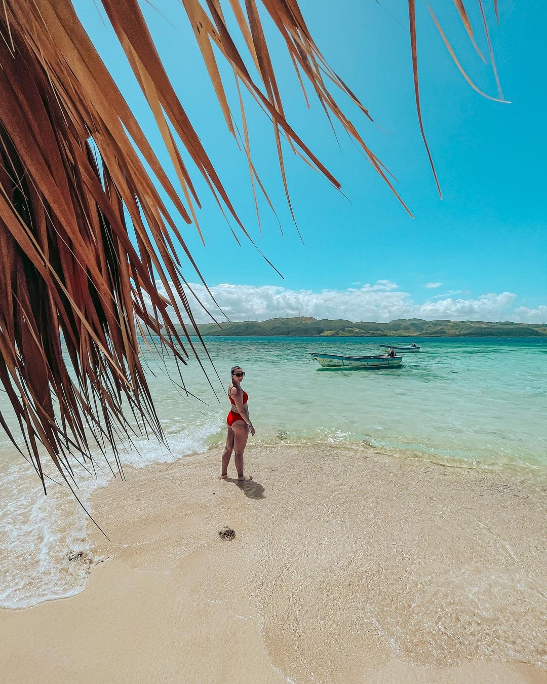 A woman walking on the shore of Playa Dorada.