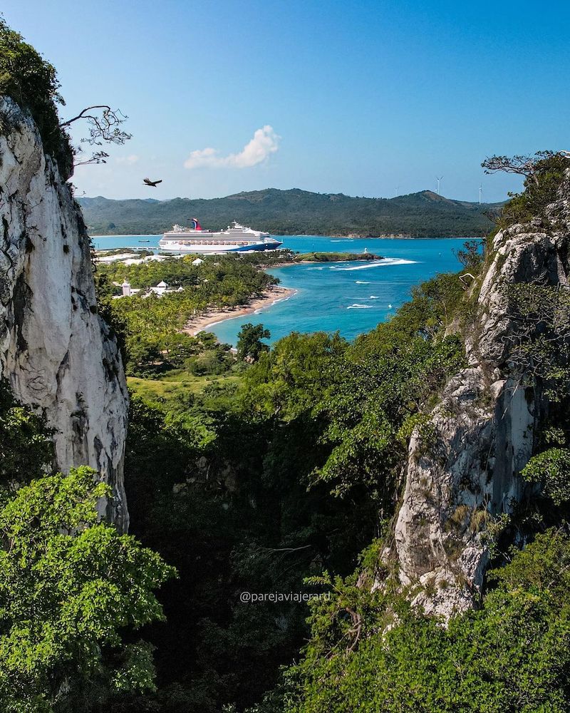 A cruise ship at Playa Teco de Maimon with mountains in the background.