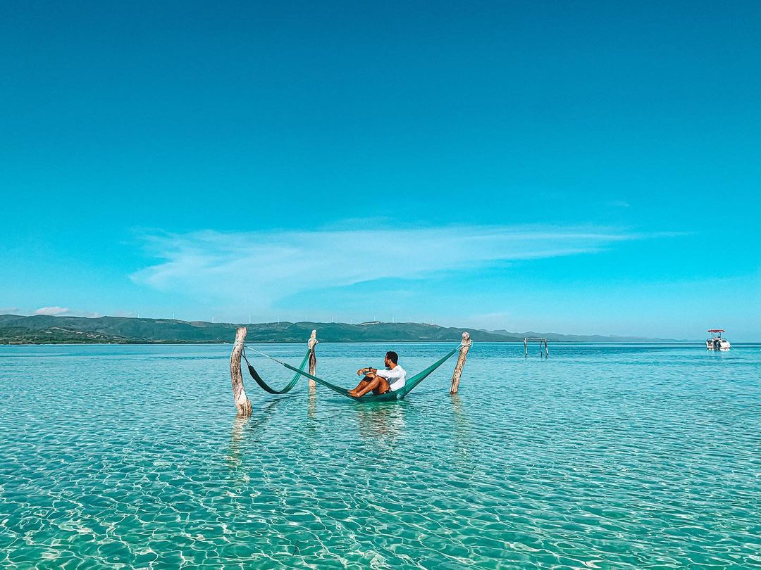 A man sitting on a hammock in the waters of Playa Punta Rucia.