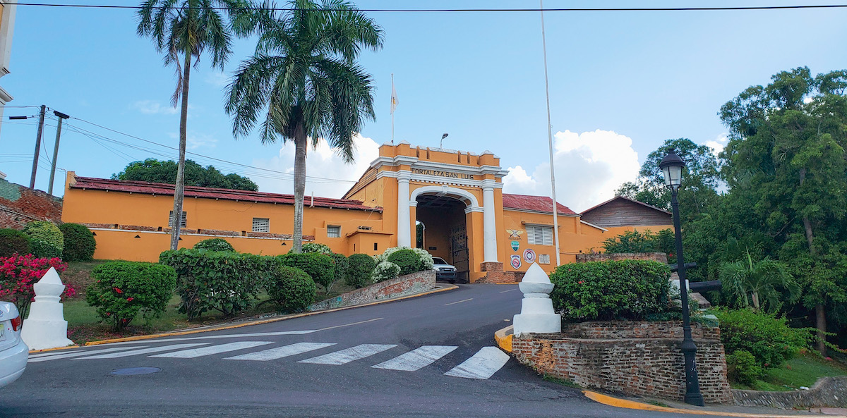The road leading to a yellow building Museo Fortaleza San Luis.