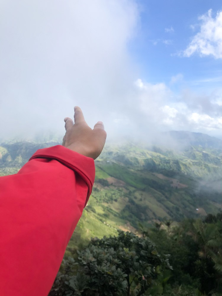 An arm reaching out to the air with a view of the Pico Diego de Ocampo in the background.