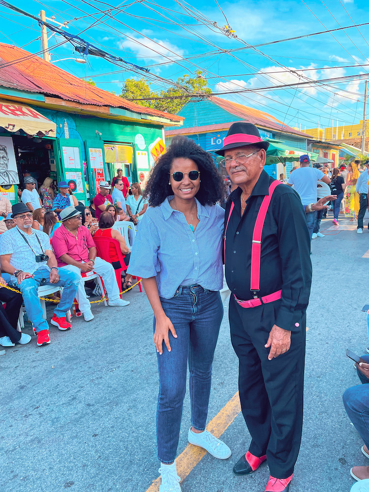 A woman standing with a man on a suit on a street.