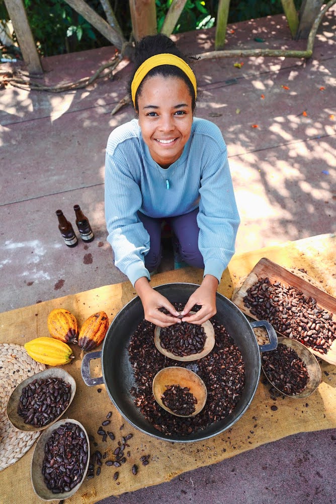 A woman with cacao beans.