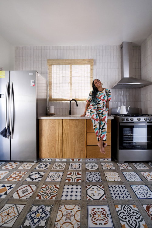 A woman sitting on a kitchen counter in an apartment in Santiago, Dominican Republic.