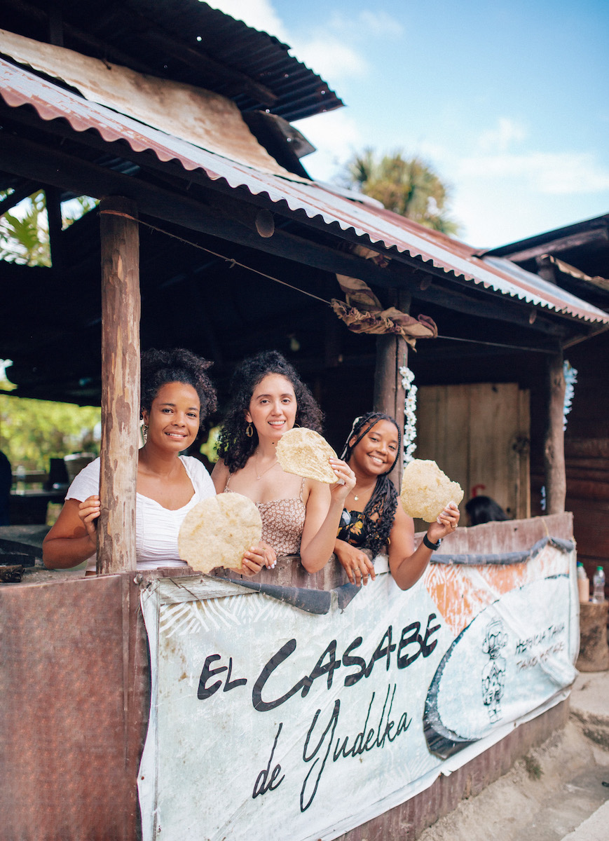 Three women holding casabe.
