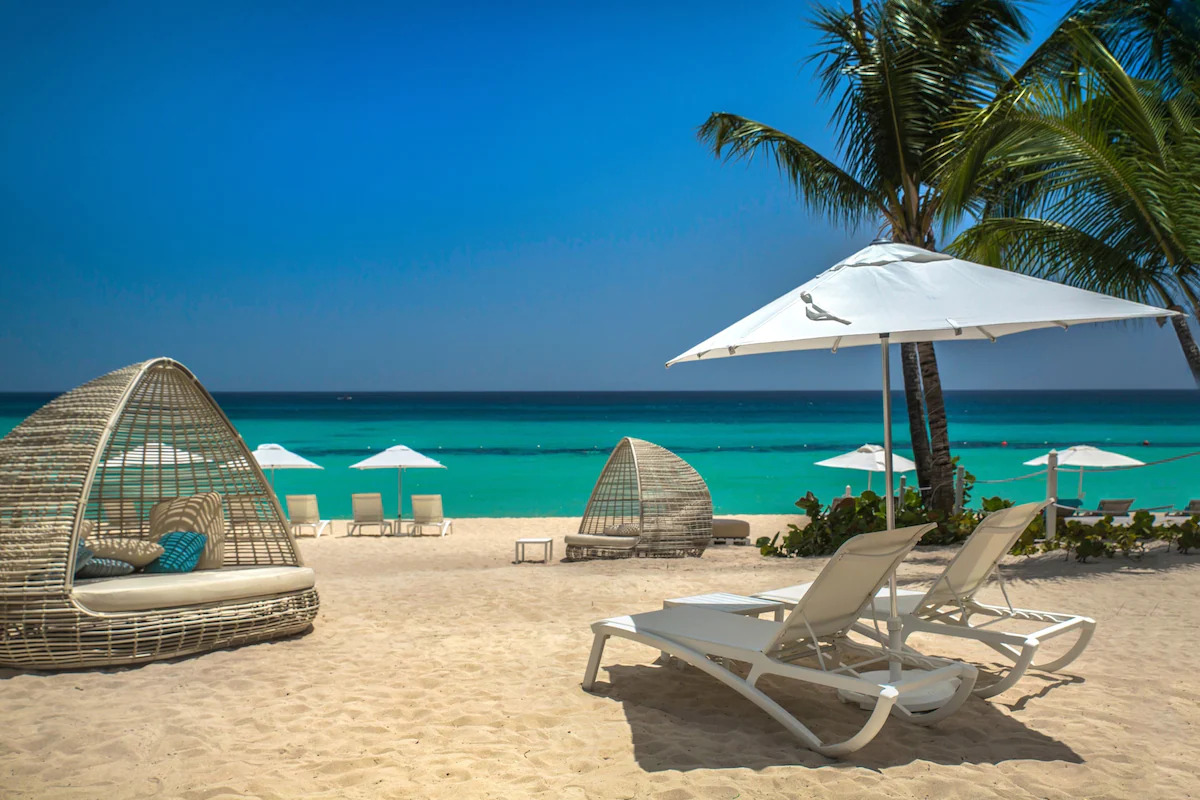 A beach with chairs and palm trees overlooking the sea in La Romana, Dominican Republic.