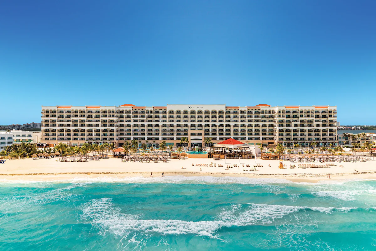 A view of a resort building and beach from the sea.