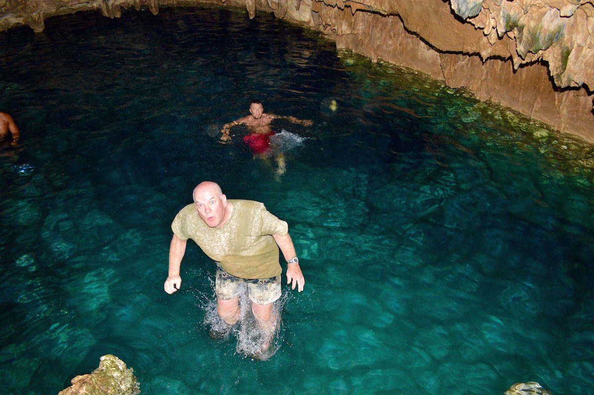 Two men swimming at Taino Cave, Punta Cana.