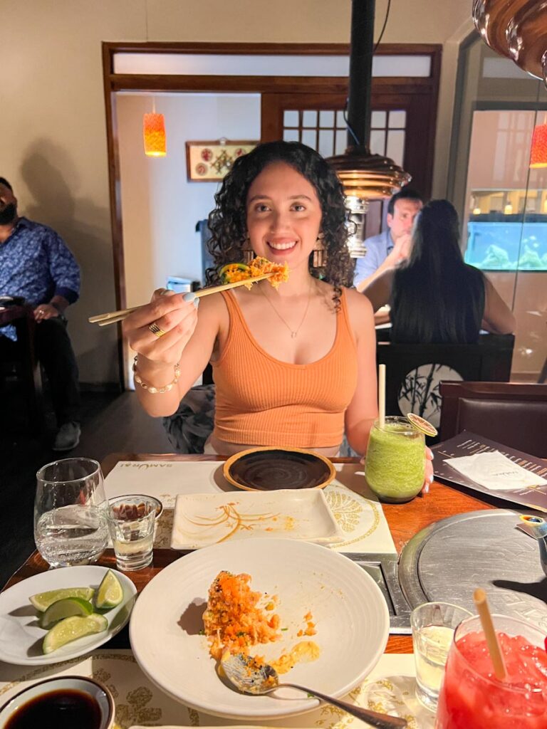 A woman eating asian food.