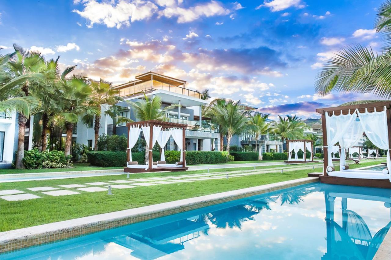 The outdoor swimming pool area with beds at a resort in Samana, Dominican Republic.